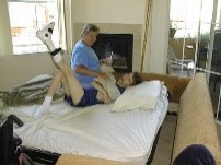caregivers stretching disabled in living room